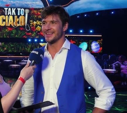 Mikołaj Roznerski w naturalnym ujęciu, pijący kawę ze swojej marki