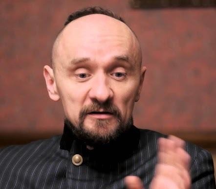 Scena teatralna oświetlona reflektorem, ukazująca perspektywę z widowni, z wyczuwalną atmosferą oczekiwania.