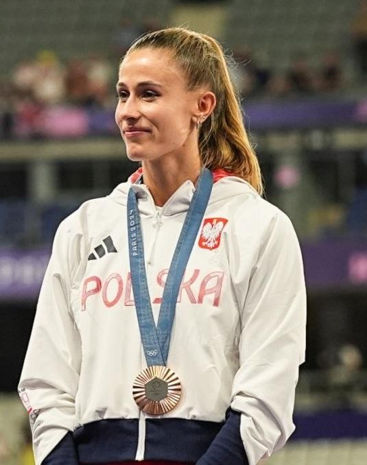 Natalia Bukowiecka podczas biegu na 400 metrów, z bliska, ukazująca koncentrację i wysiłek, z rozmytym tłem stadionu.