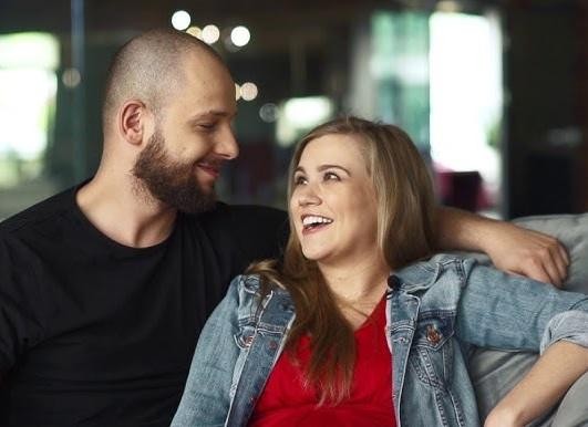 Maciej Pela z dwiema córkami, Emilią i Gabrysią, w ciepłym, rodzinnym ujęciu, uśmiechnięci i zrelaksowani.