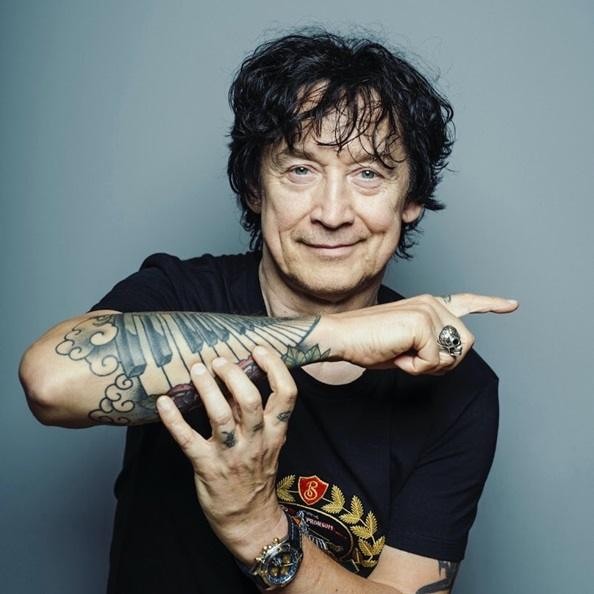 Jan Borysewicz w młodości, trzymający gitarę, czarno-białe zdjęcie z lat 80., ukazujące początki Lady Pank i ducha polskiego rocka.