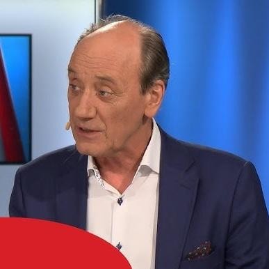 Dariusz Szpakowski w studiu komentatorskim, pełen pasji podczas relacjonowania wydarzenia sportowego.
