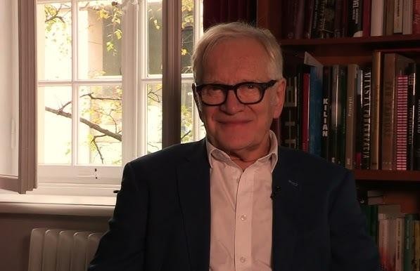 Andrzej Seweryn w dynamicznej scenie filmowej, ukazujący intensywność i zaangażowanie w rolę aktorską.