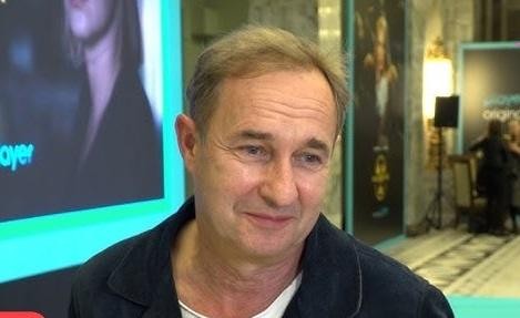 Marek Kalita w swoim domu w Puszczy Kampinoskiej, zamyślony, z widokiem na las, symbolizujący jego życie prywatne i związek z naturą.