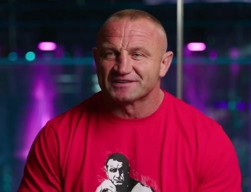 Mariusz Pudzianowski w akcji podczas walki MMA, prezentujący siłę i determinację.