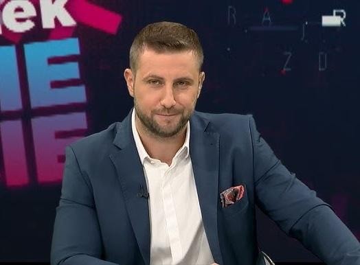 Miłosz Kłeczek podczas ostrej wymiany zdań w studiu telewizyjnym, z intensywnym wyrazem twarzy, w dynamicznym ujęciu.