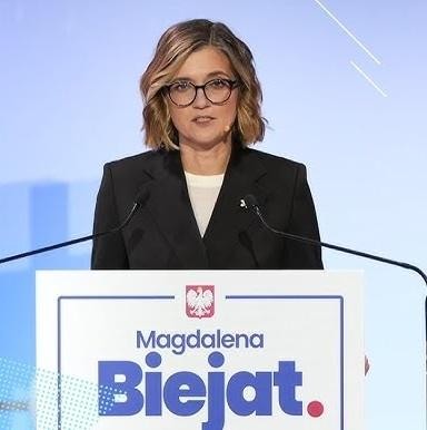 dynamiczny obraz Magdaleny Biejat podczas wystąpienia publicznego, podkreślający jej zaangażowanie i pasję polityczną.